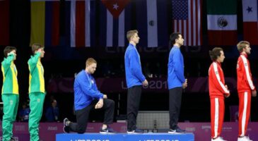 Un fleurettiste genou à terre pendant l’hymne américain