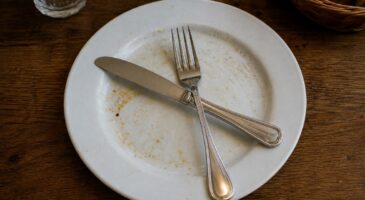 Que signifie le fait de disposer les couverts en croix sur l'assiette et à quel moment faut-il le faire ?